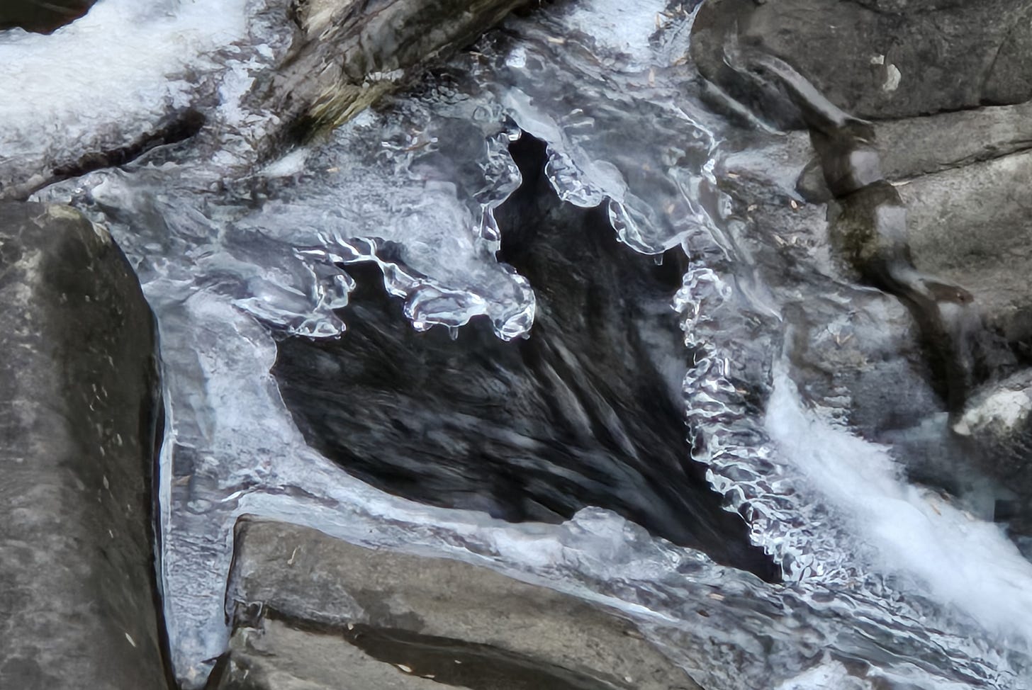 A hole in ice over a stream forms the shape of a heart