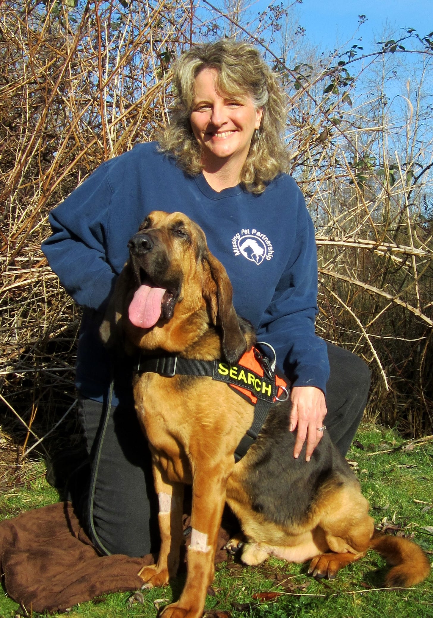 Kat Albrecht and her bloodhound Zeke posing in a portrait picture