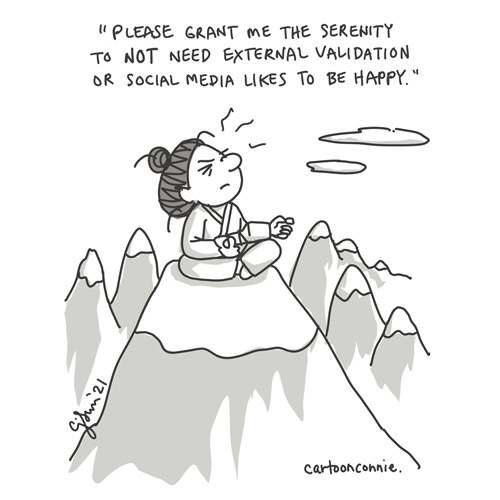 Single-panel cartoon of a women on a mountain top, exerting great effort to be zen. Caption reads: "Please grant me the serenity to not need external validation or social media likes to be happy." Comic by Connie Sun, cartoonconnie