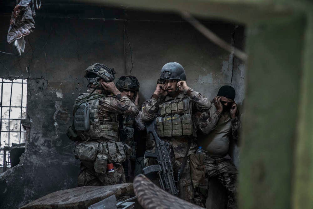 Des soldats attendent l’explosion pour pouvoir pénétrer dans la maison attenante.