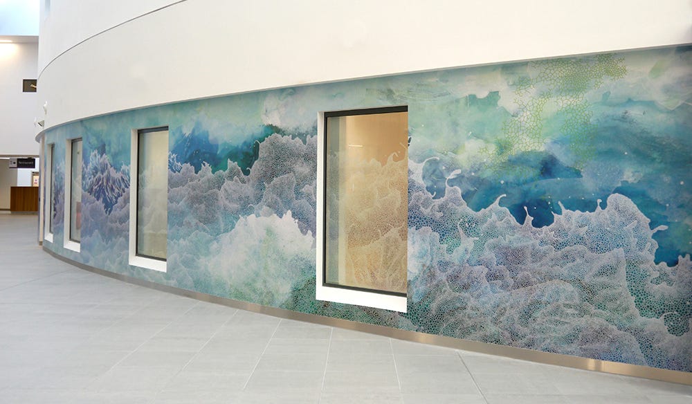 A mural of crashing waves in blue-green and white