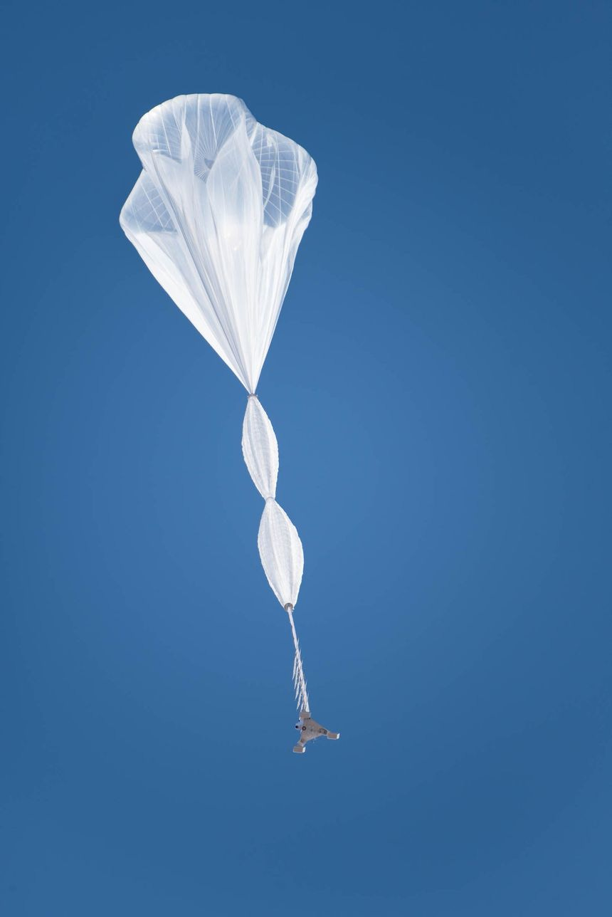 A large white translucent balloon floats to the sky