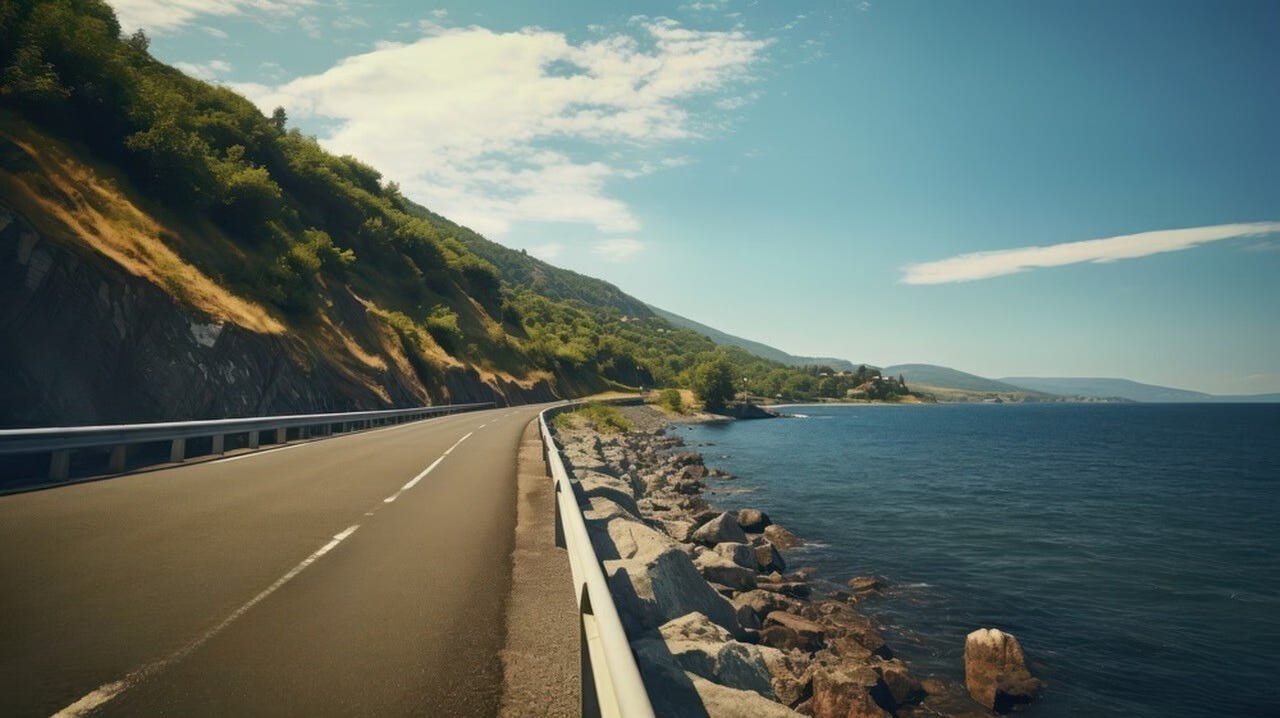 an open road alongside the sea