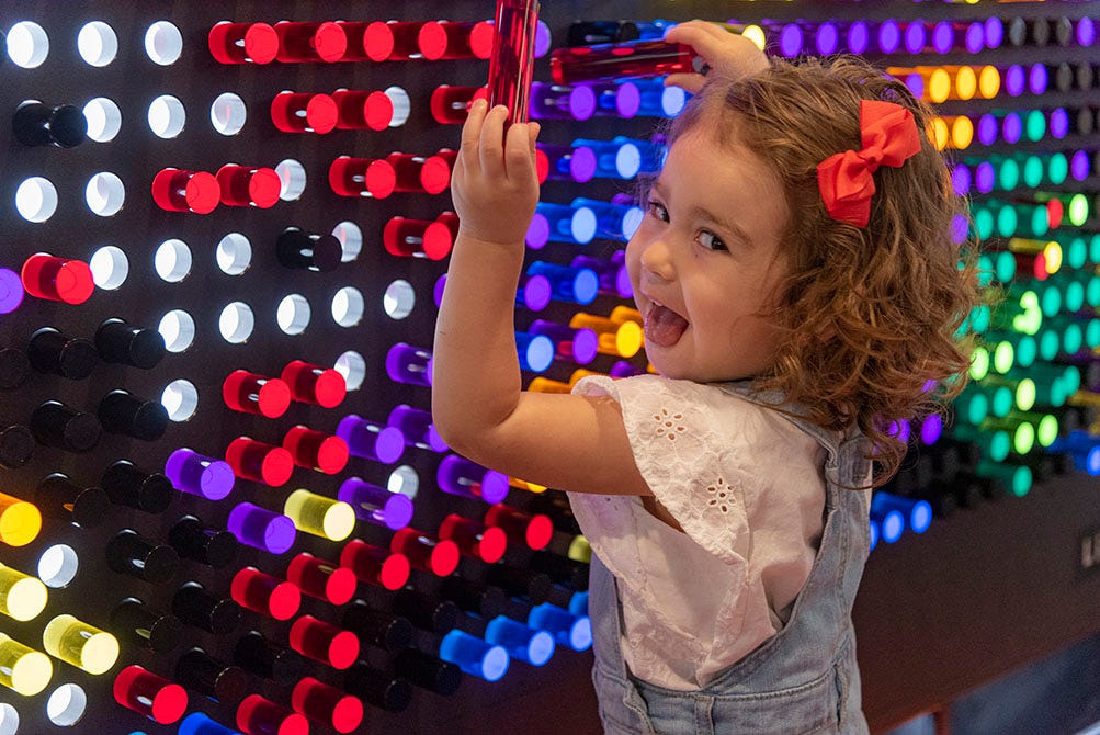 Young girl plays with the LiteZilla, a large interactive light display. 