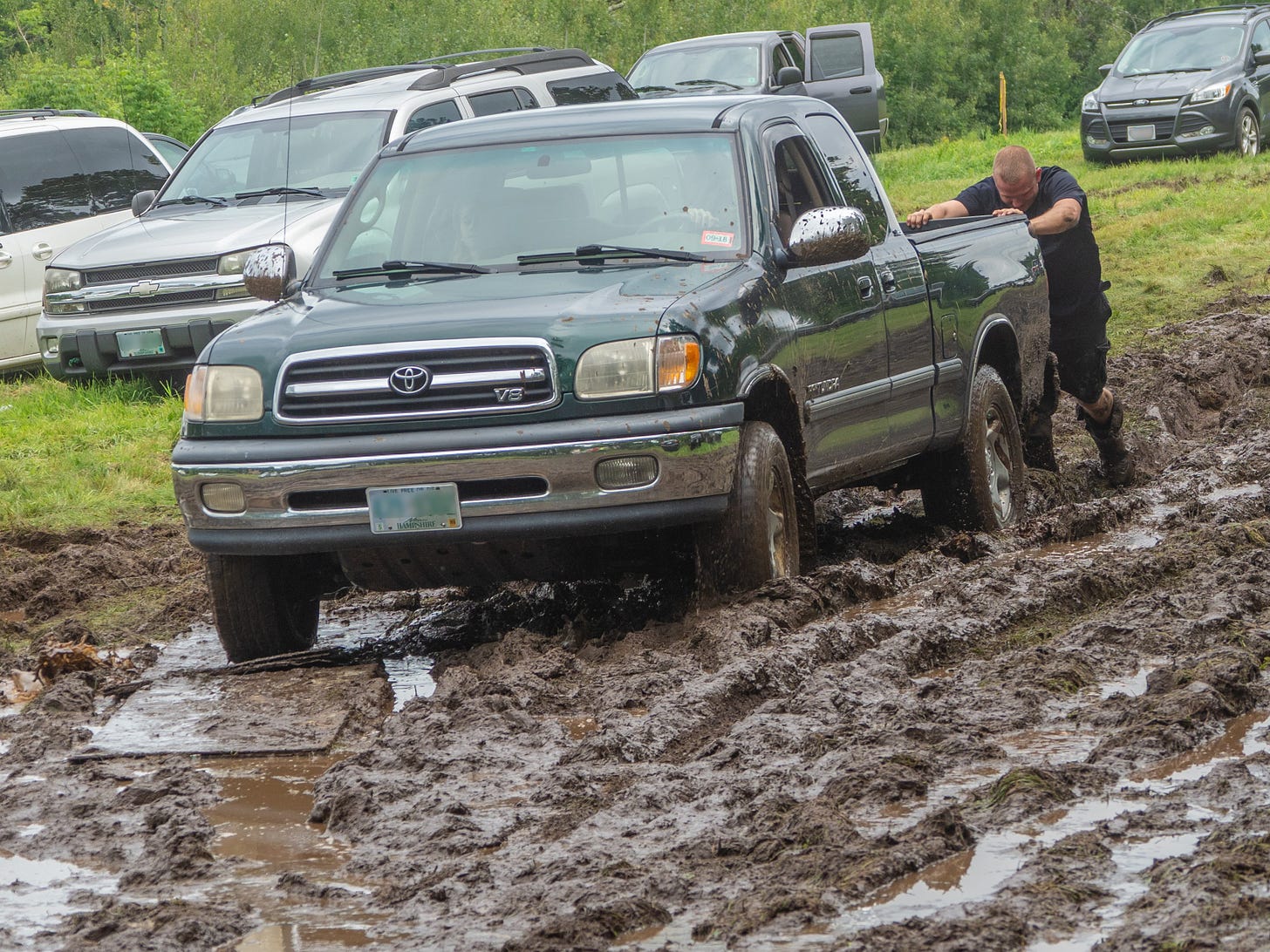 Man pushing truck out of mud