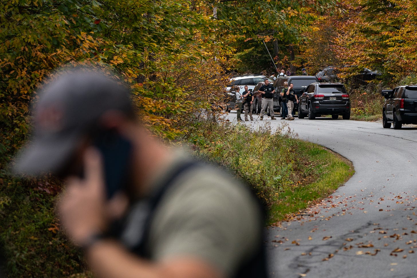 Law enforcement personnel gather outside the suspect home in Bowdoin, Maine, Thursday, October 26. A manhunt is underway after gunman kills at least 18 people in Lewiston, Maine.