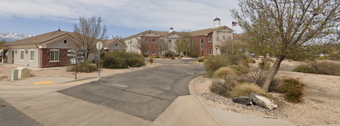 A picture of a building with a driveway in front of it