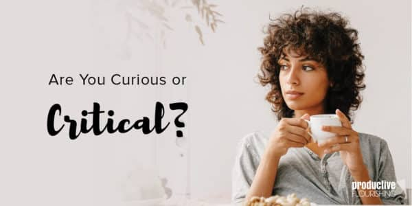 A woman with short curly hair is holding a small white mug, face turned to the left. Text Overlay: Are You Curious Or Critical?