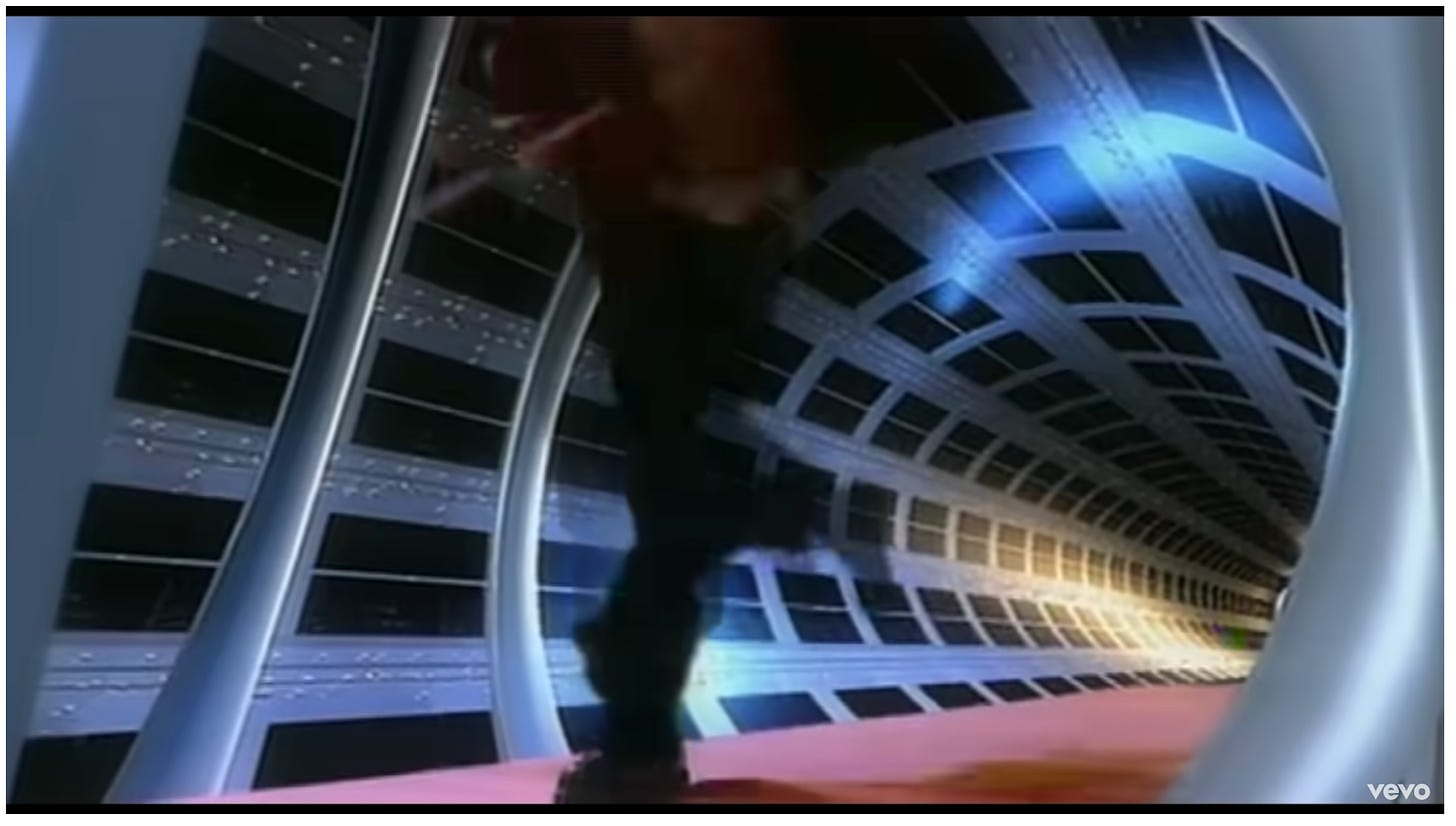 A silhouette with a slightly discernible red jacket is racing down a space tube with windows all over it
