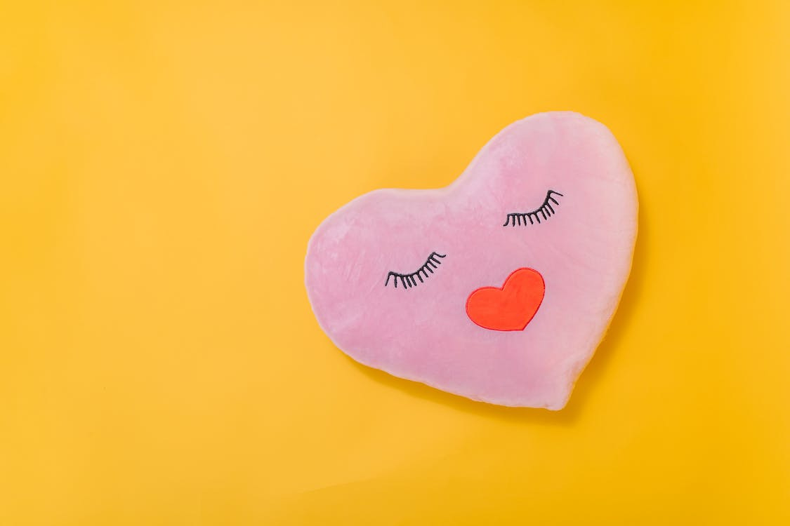 Free Pink Heart Shaped Pillow on Yellow Surface Stock Photo