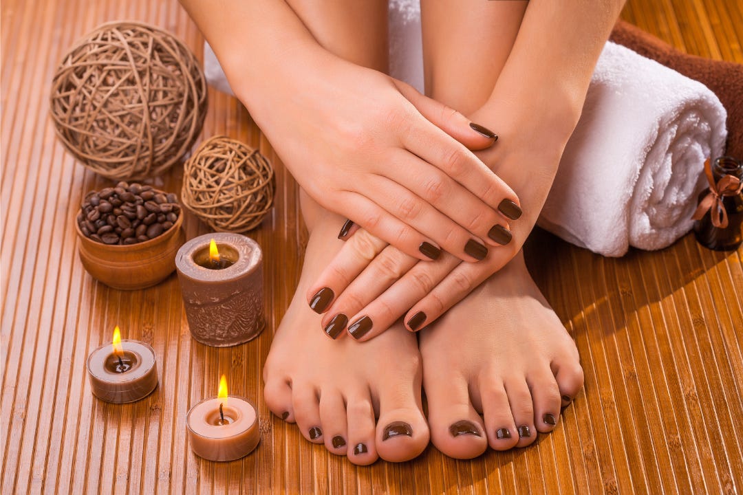 hands and feet with carefully done nails, amidst candles