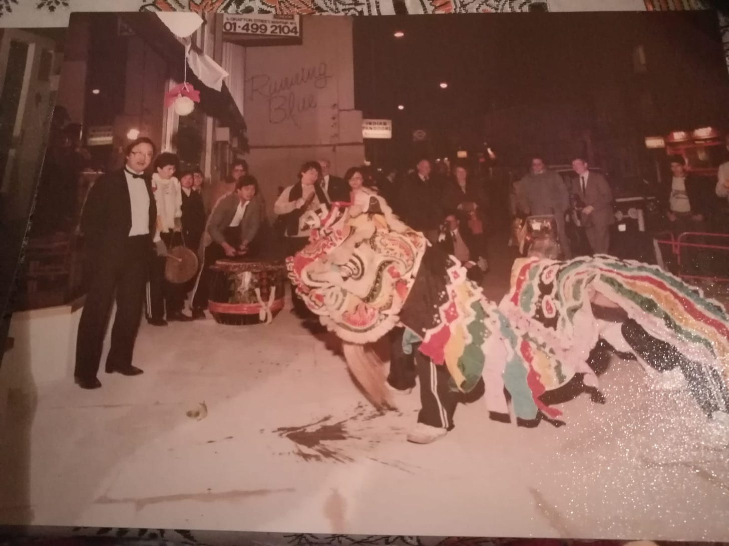 image of an old photo capturing the traditional lion dance that celebrates and imparts luck onto new Chinese businesses on their first day of operations