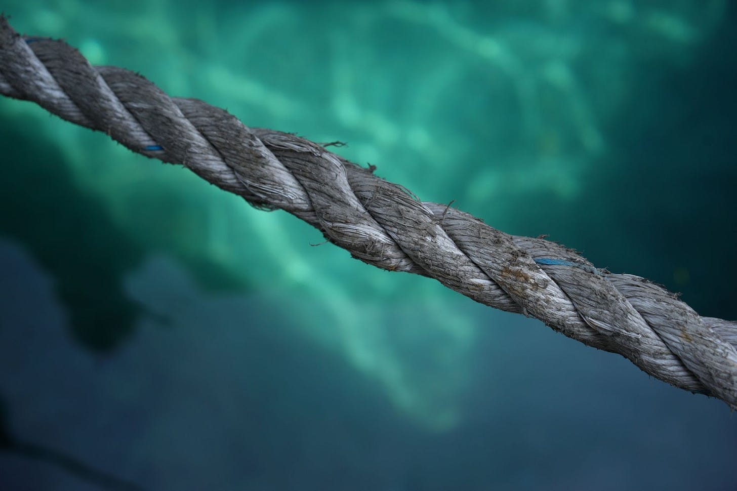 A rope pulled taught over a blue-green pool of water. A rope pulled taught over a blue-green pool of water.