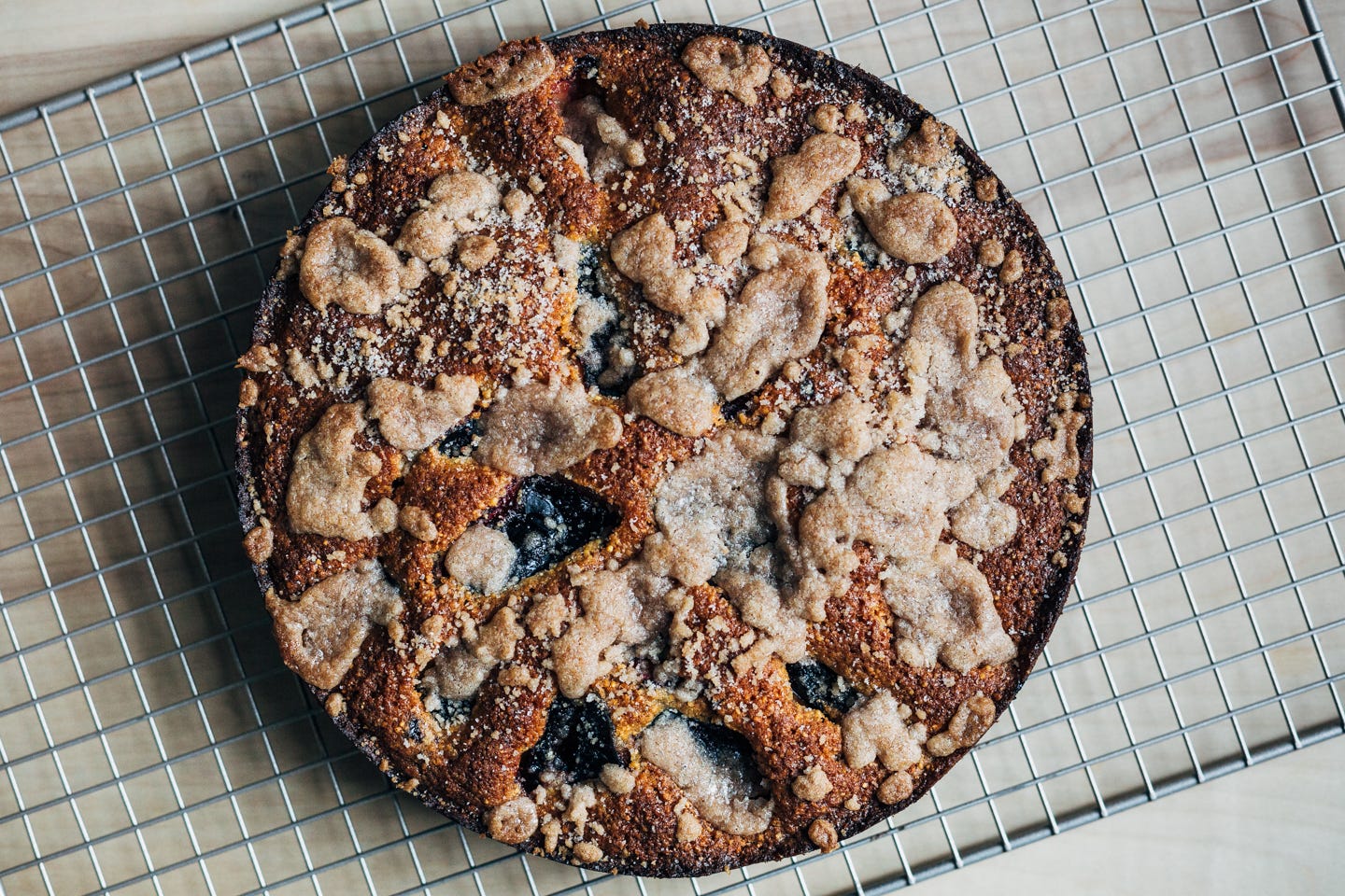 Plum cake on a cooling rack seen from overhead. 