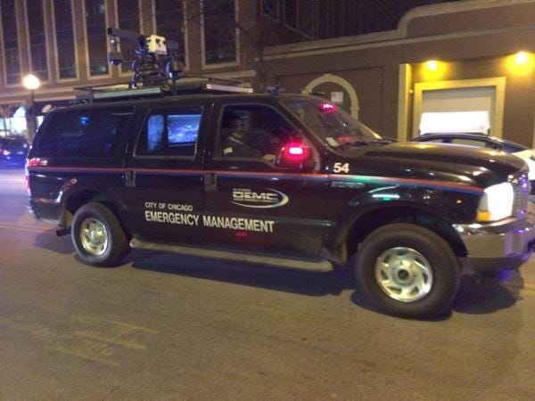 Photo of a black SUV with "city of chicago emergency management" on the side and a strange radar-like apparatus on the roof.