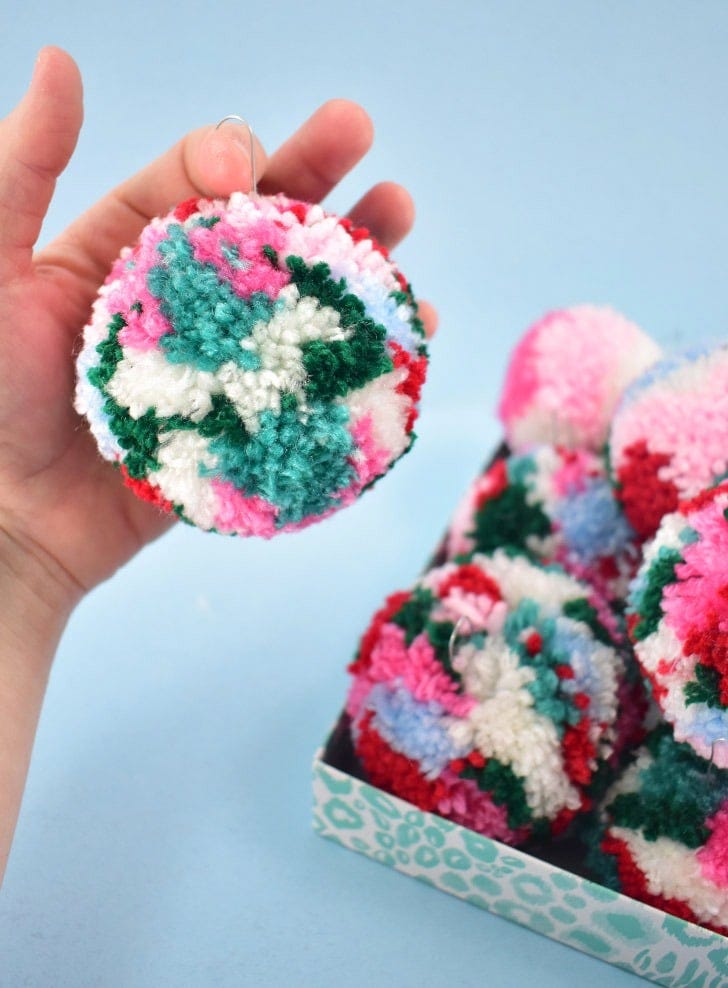 If you're looking to add some fun and color to your Christmas tree look no further. These DIY multicolored pom pom ornaments are adorable and inexpensive!