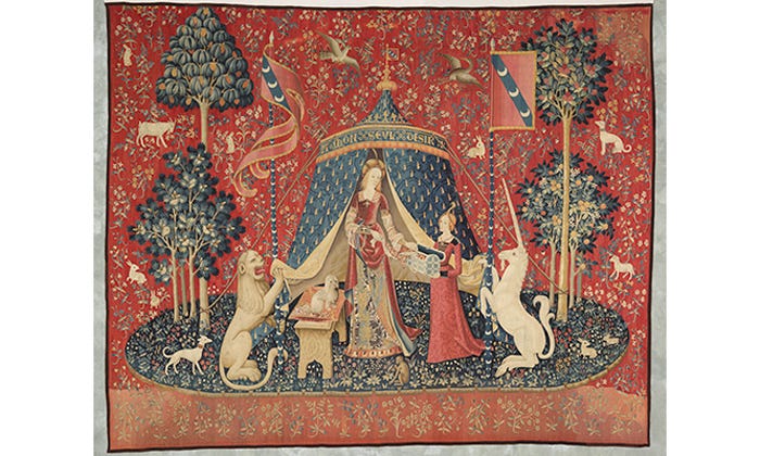 Arazzo medievale che mostra due donne in abiti rossi circondate da un unicorno, un cane e un leone su uno sfondo rosso decorato da fiori