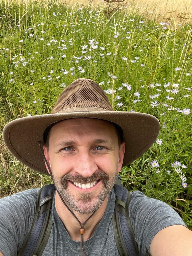 A person taking a selfie in a field of flowers

Description automatically generated