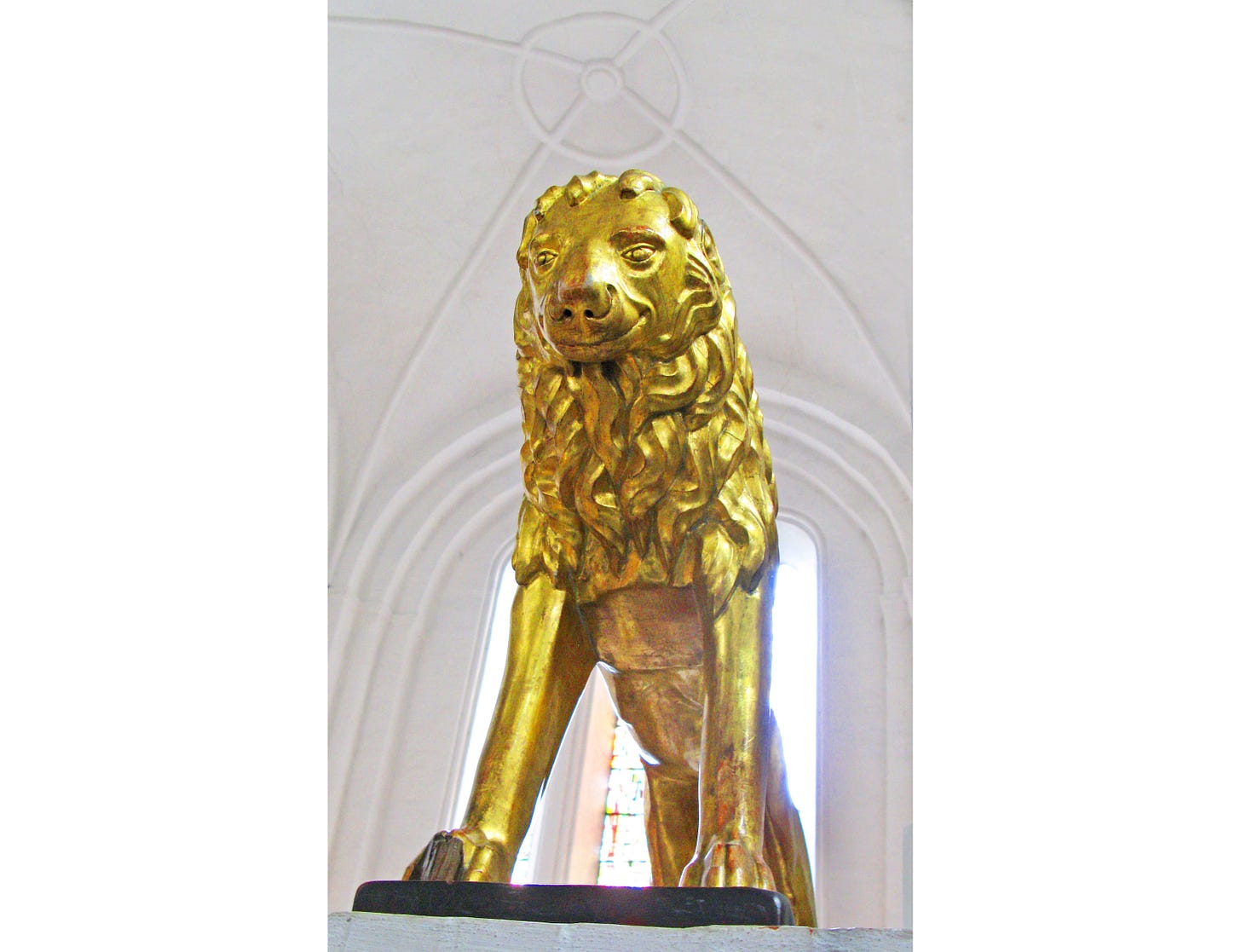 Eine goldene Löwin mit zum Lächeln hochgezogenen Mundwinkeln.