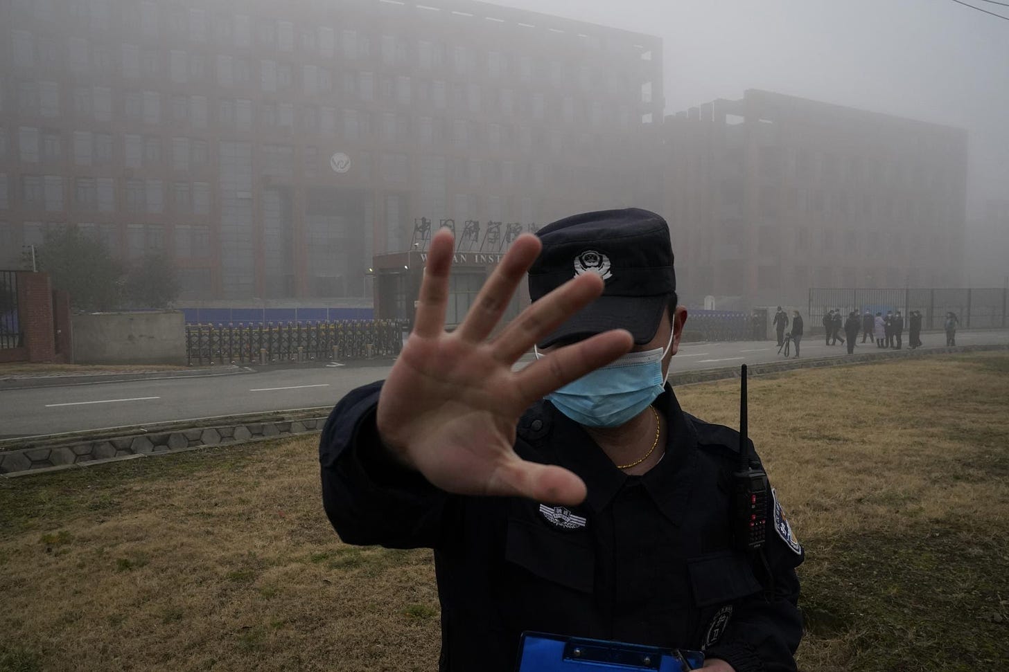 Security moves journalists away from the Wuhan Institute of Virology.