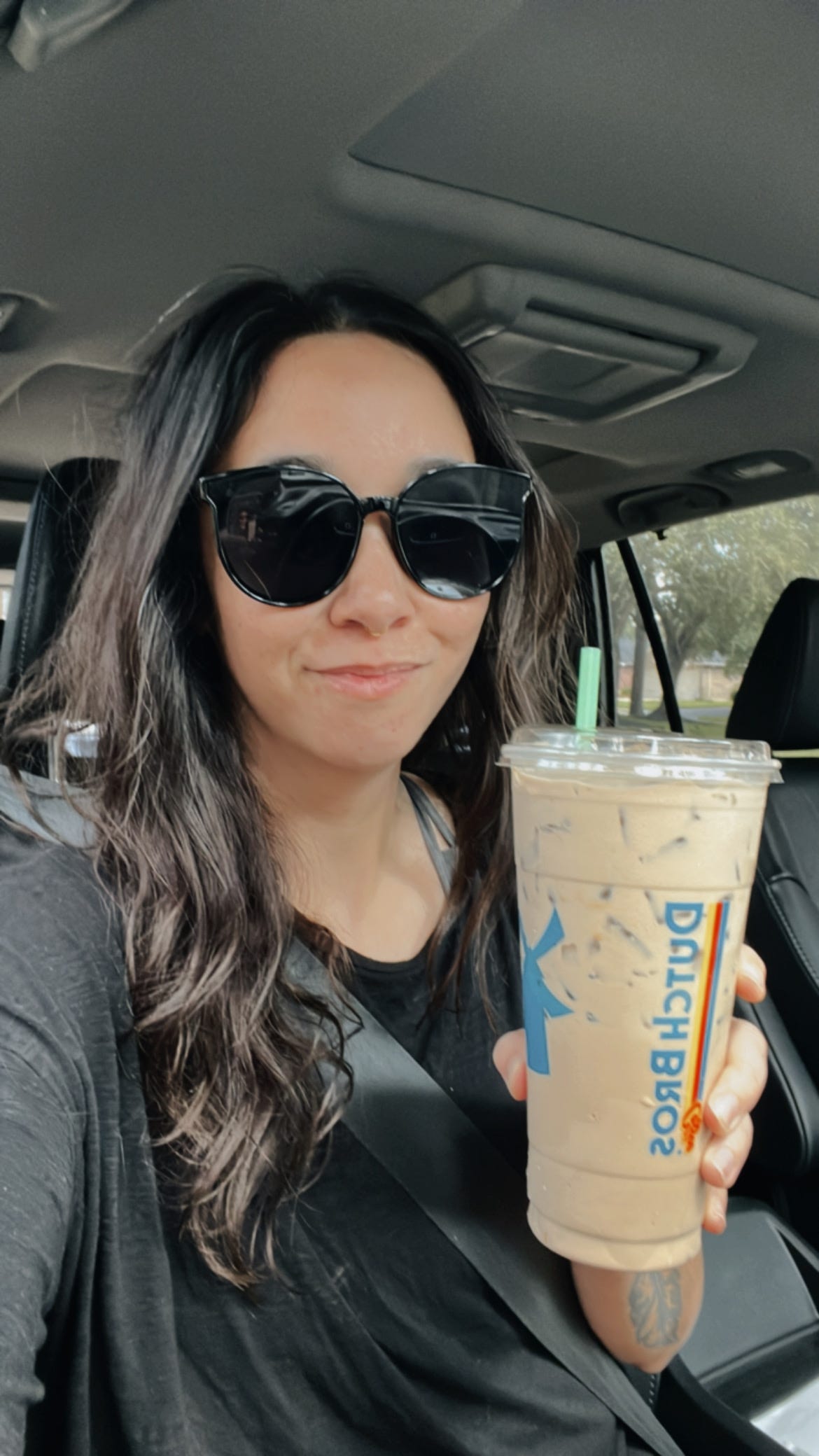 Image of Jenai holding up a coffee drink from Dutch Bros.
