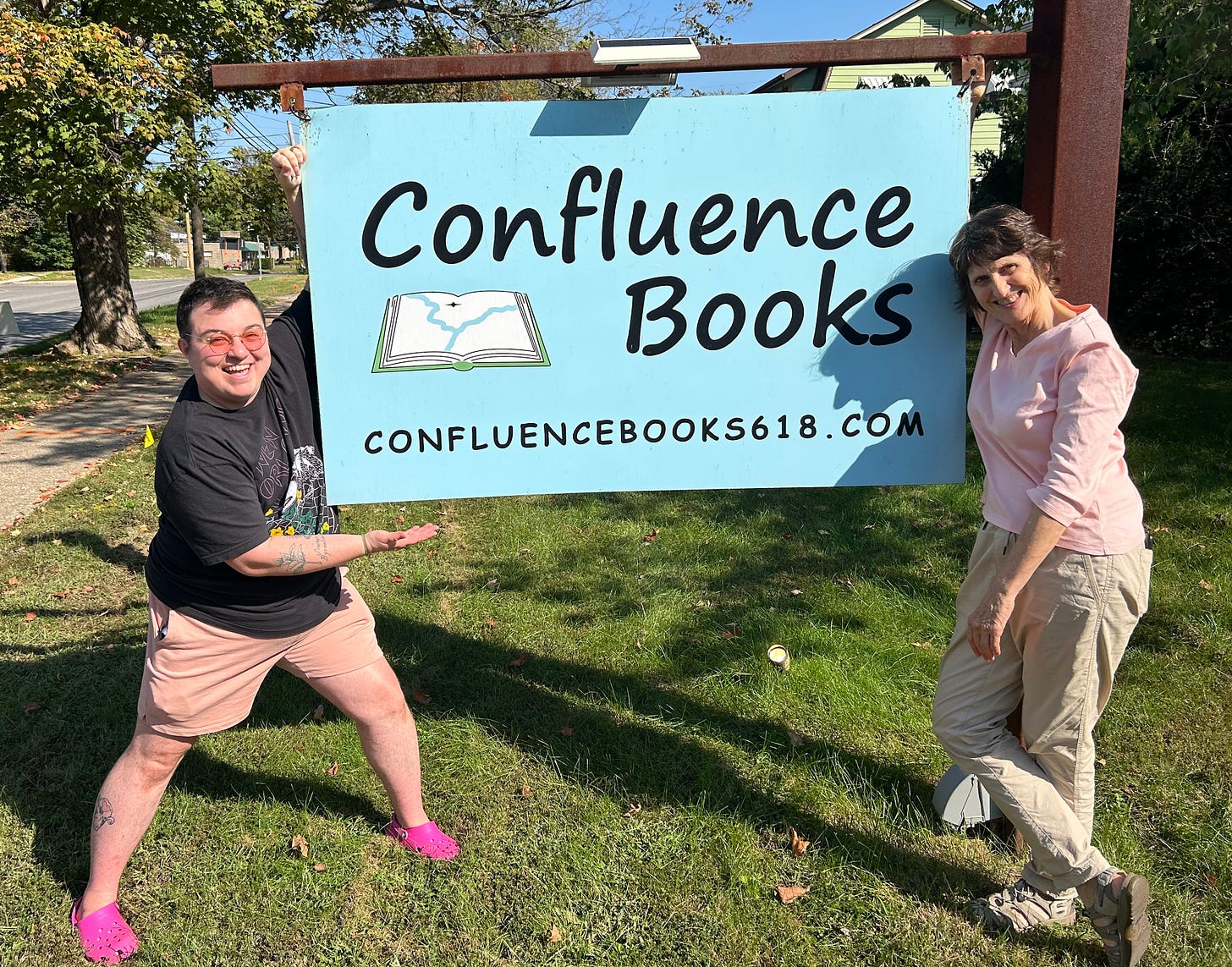 Raf and Confluence owner Sarah Heyer with Confluence Books sign