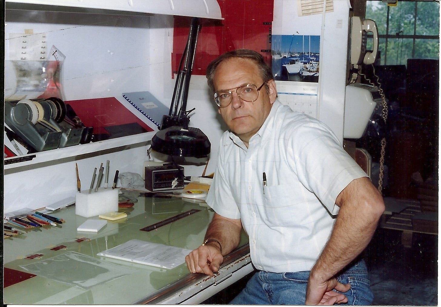 1980s era man sitting in front of a drafting table at work