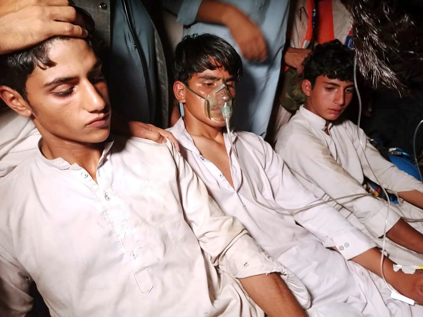Youngsters, left, who were trapped in a broken cable car, receive first aid following their rescue, in Pashto village, a mountainous area of Battagram district in Pakistan's Khyber Pakhtunkhwa province, Tuesday, Aug. 22, 2023. 