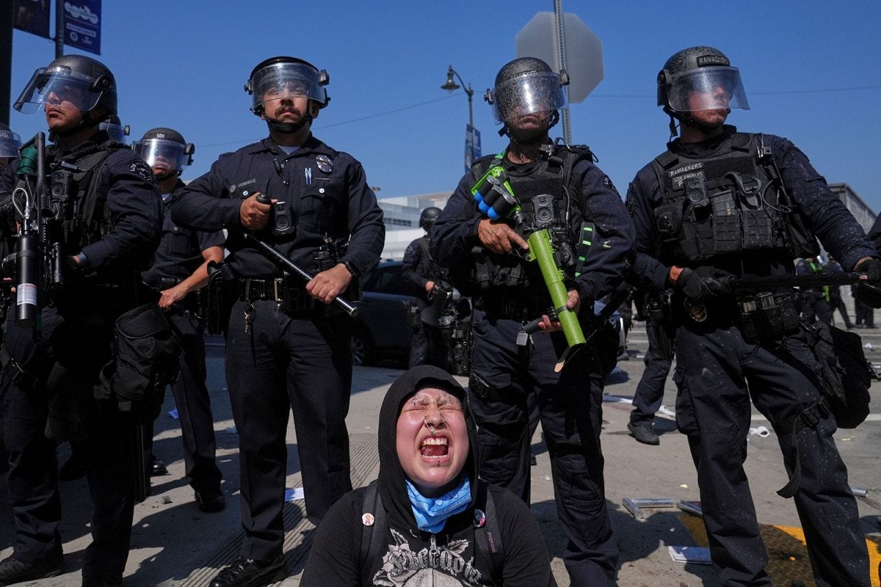 A woman screams as protesters confront a line of police near the Metropolitan Detention Center in Downtown Los Angeles on Sunday.