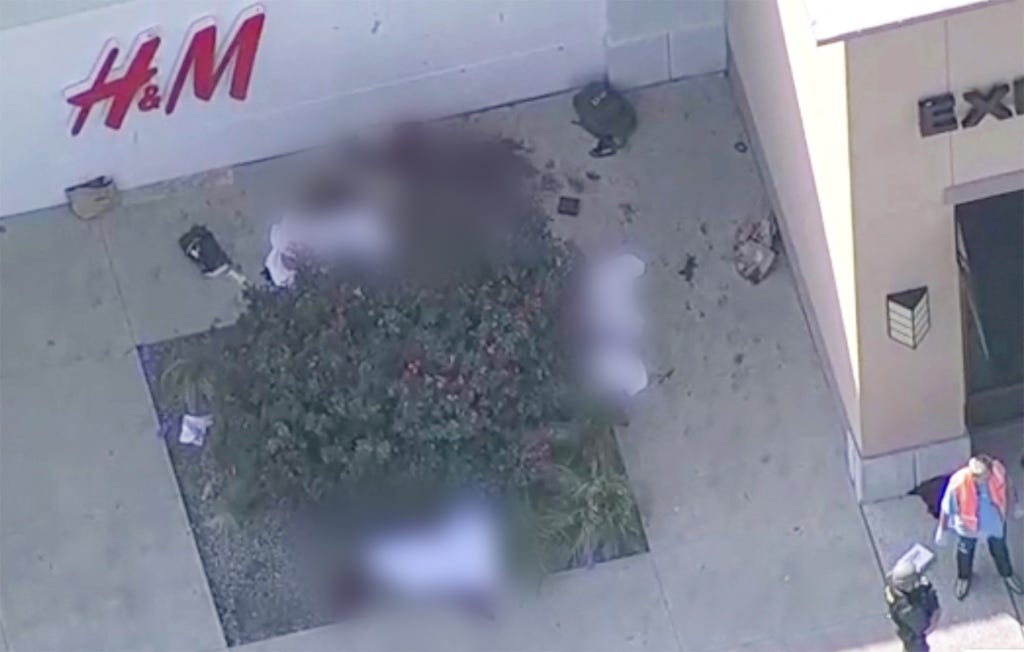 Aerial footage broadcast on local news stations appeared to show at least four bodies hidden underneath white sheets in an outdoor area of the mall.