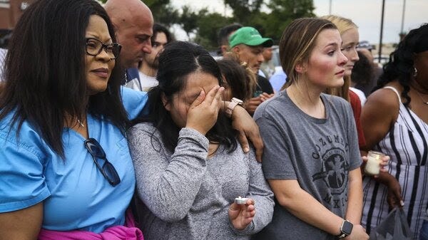 Adriana Rosales, center, wipes her face from tears during a candlelight vigil for the victims of Saturday’s shooting Sunday, May 7, 2023, at Allen Premium Outlets in Allen.