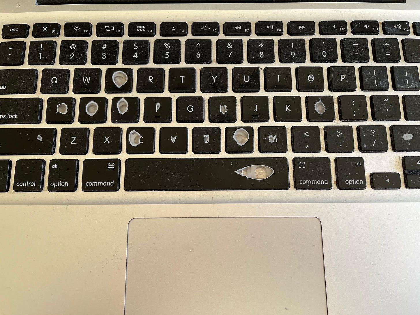 Photo of a very worn and overused Macbook keyboard.