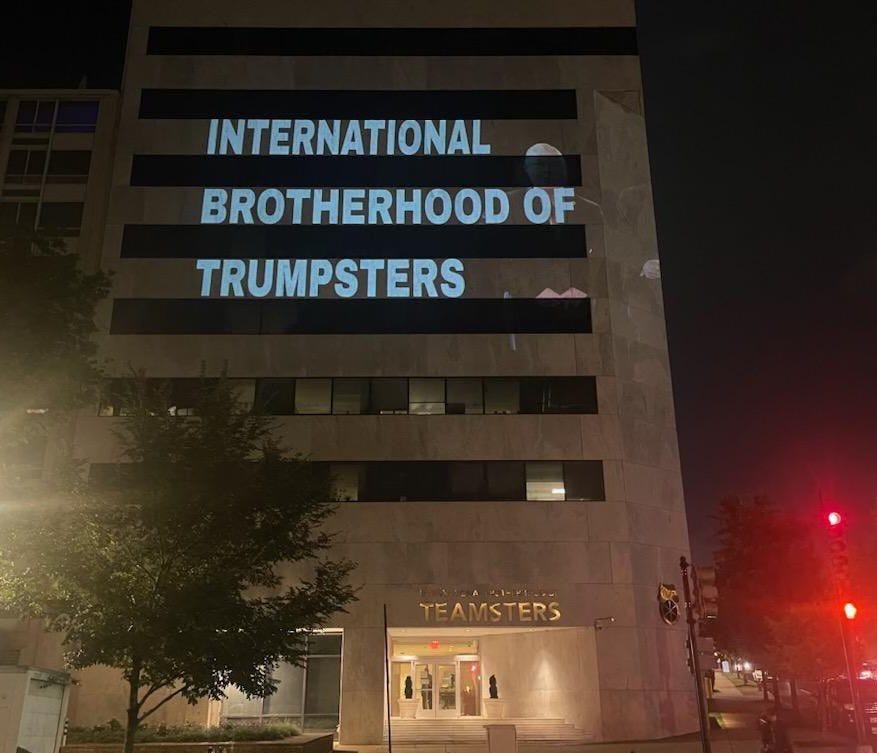 The words “international brotherhood of trumpsters” projected onto a blocky tan building (the teamsters hq in DC)