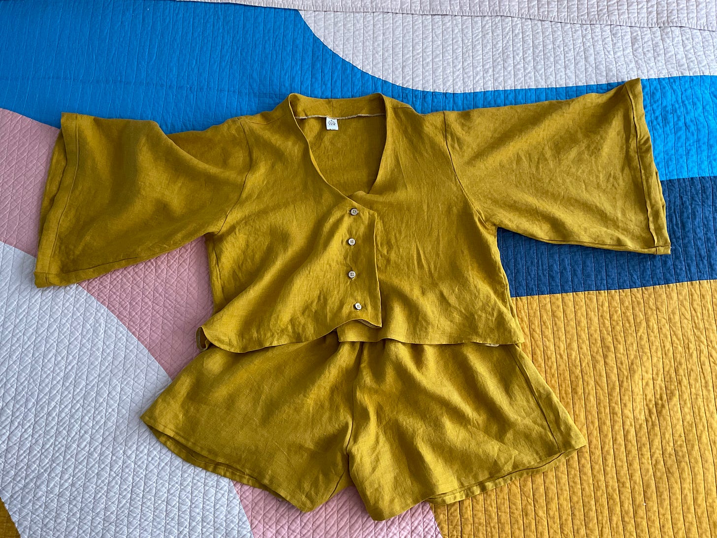 Mustard colored loungewear short set laying on a bed