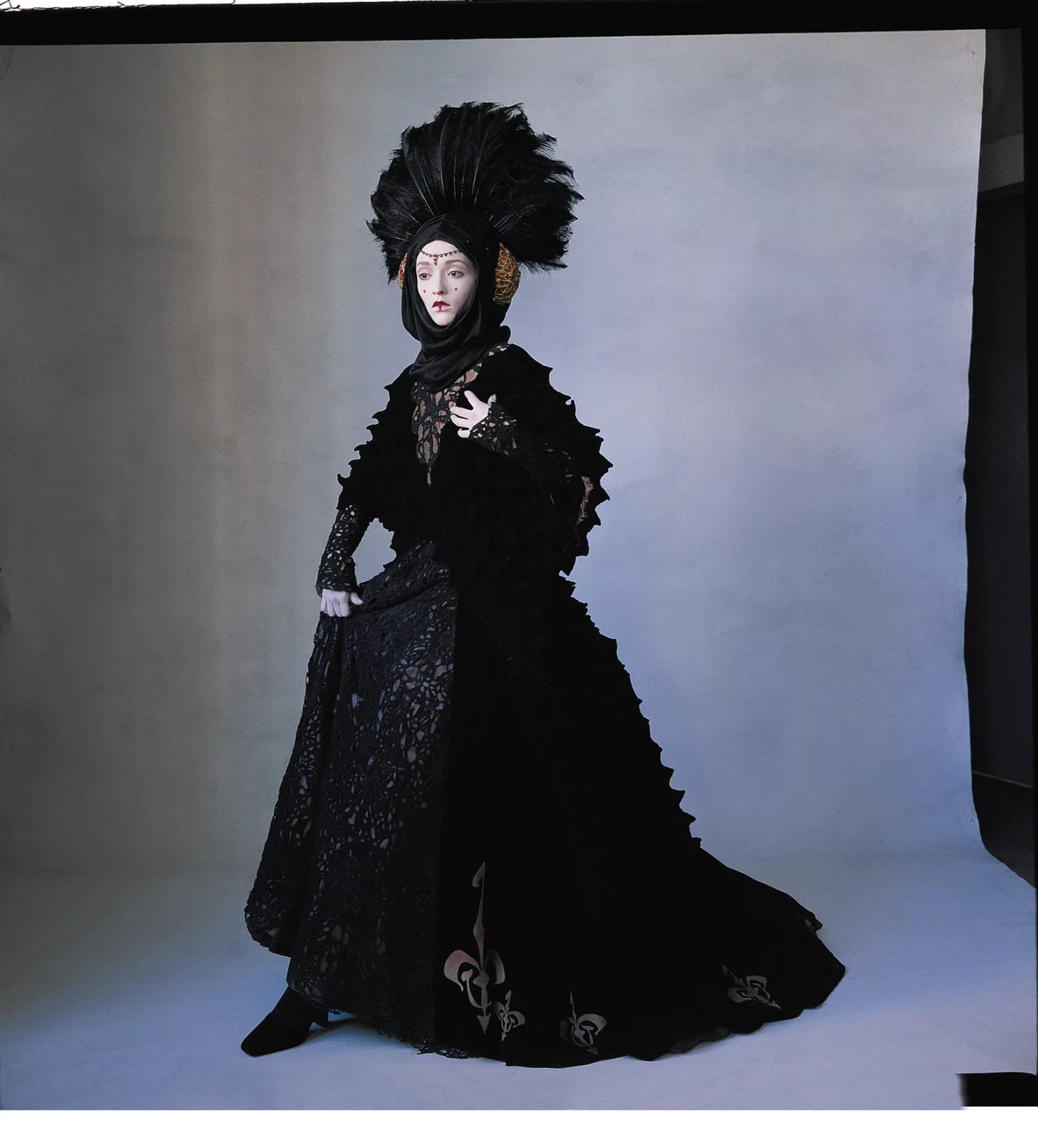 A woman wearing an ornate black dress and headdress