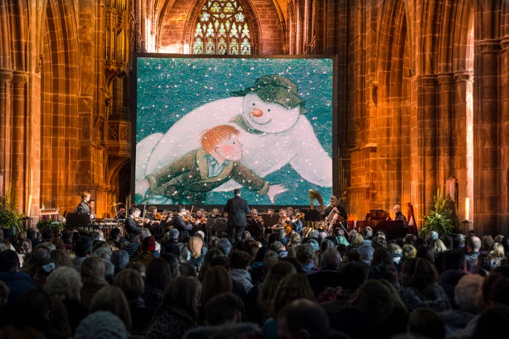 An audience watching The Snowman on a large screen