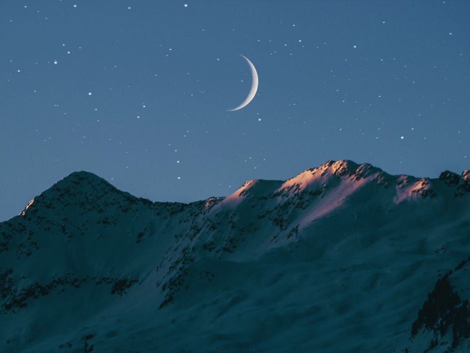 crescent moon above mountain