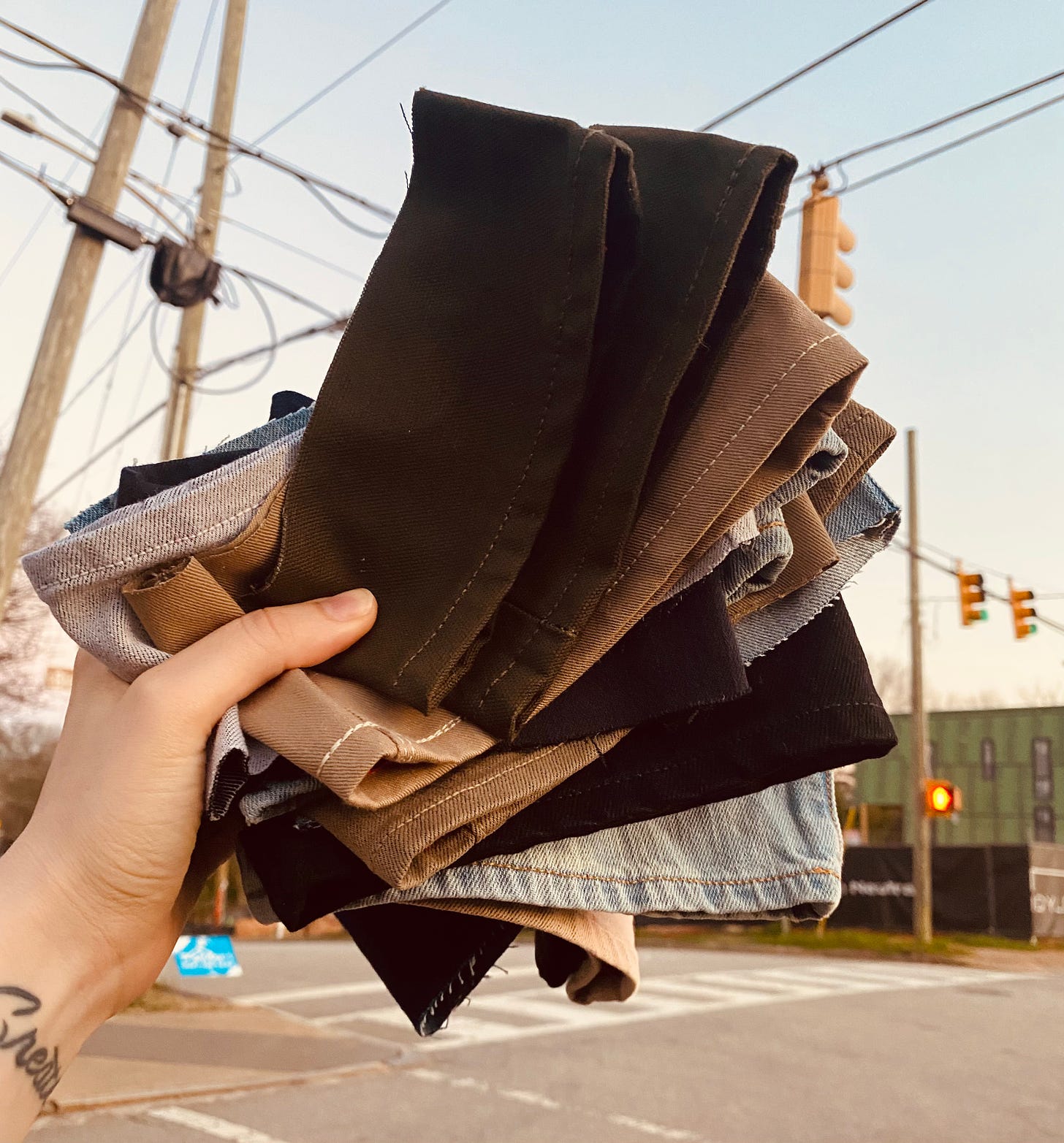 Me holding the fabric scraps in front of an intersection in Raleigh.