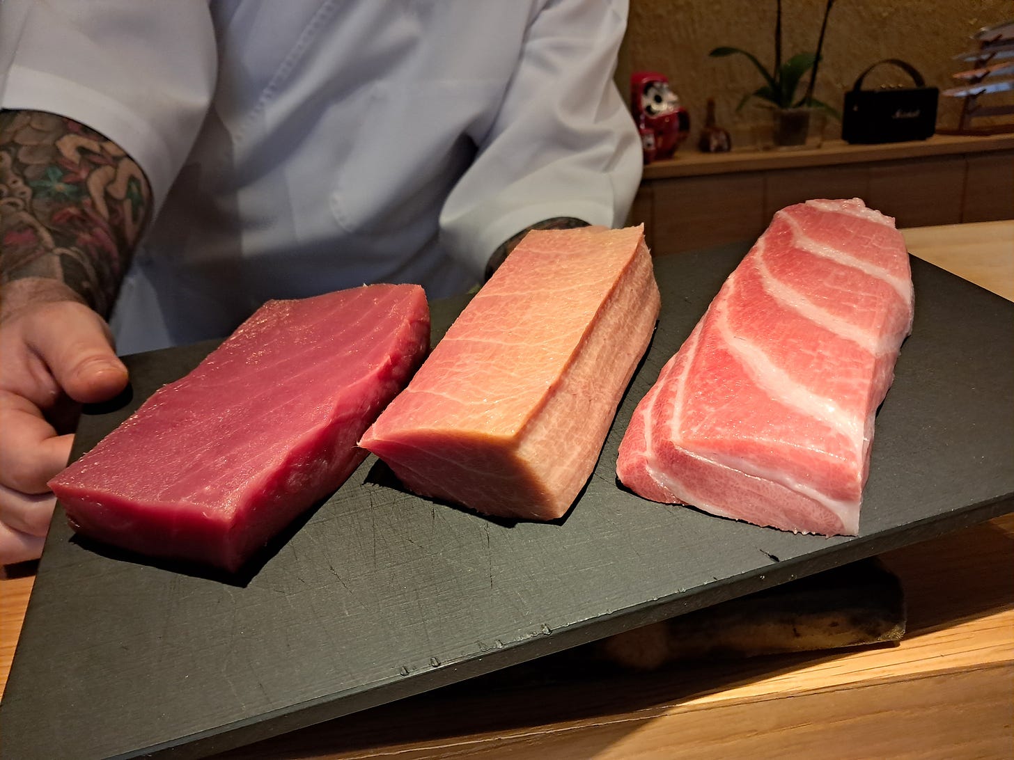 Tabla de chef con tres tacos de atún de diferentes calidades