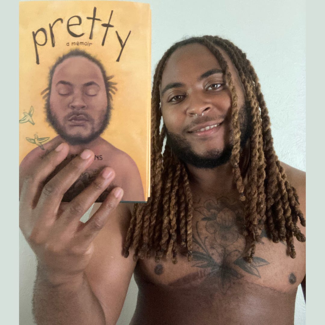 Now-adult KB, holding a copy of PRETTY. 