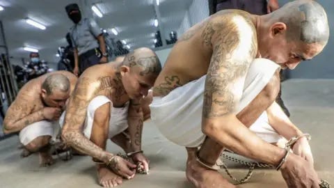 Reuters Prison agents guard gang members as they are processed at their arrival after 2000 gang members were transferred to the Terrorism Confinement Center