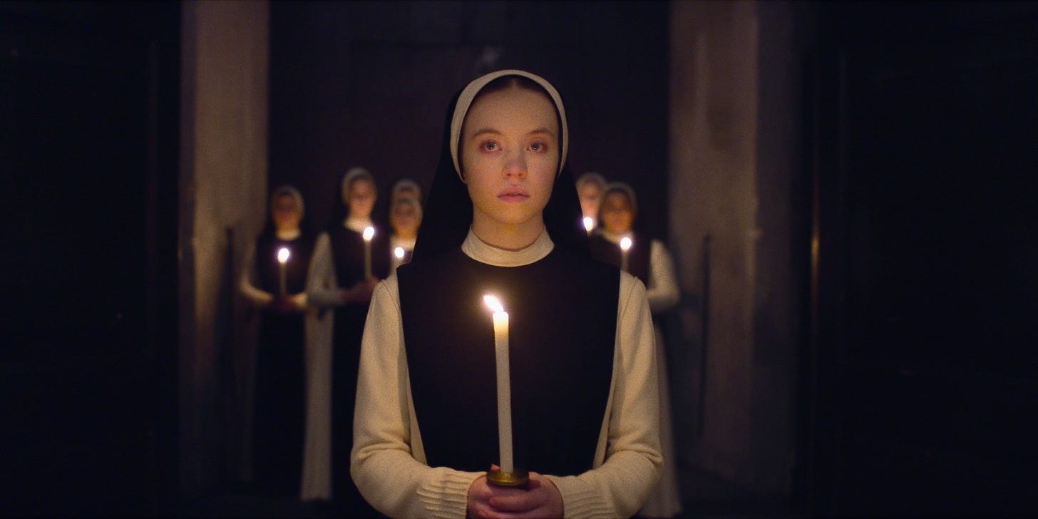 Young nuns hold candles