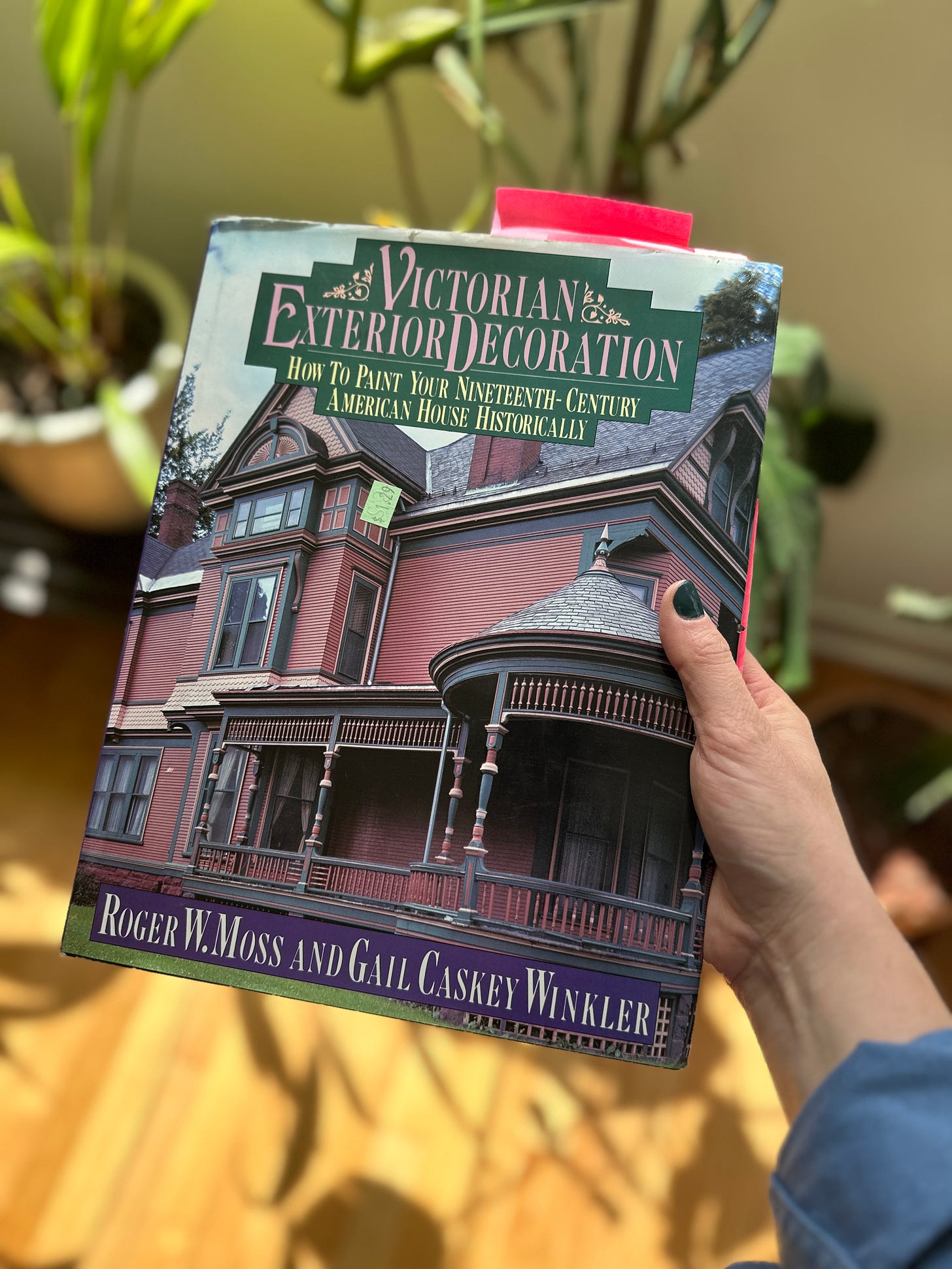Cover of Victorian Exterior Decoration: How to Paint Your Nineteenth-Century American House Historically, which features an elaborate Queen Anne Victorian House painted plum with dark trim. 