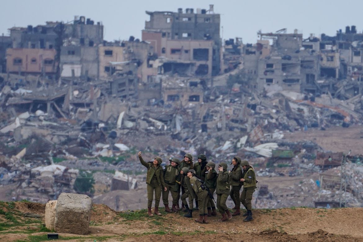 Israeli female soldiers pose for a photo on a position on the Gaza Strip border