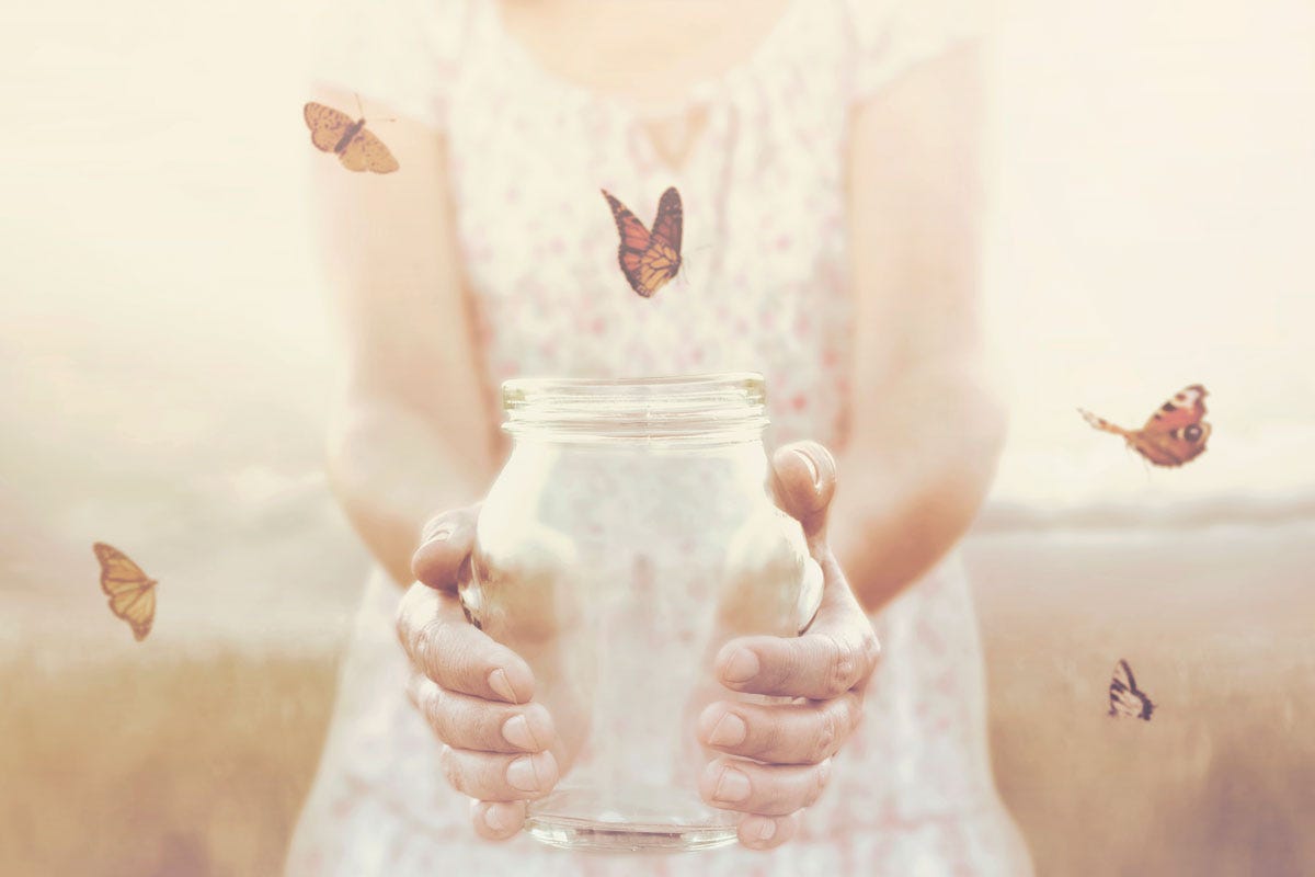 Woman Releasing Butterflies from a Glass Jar
