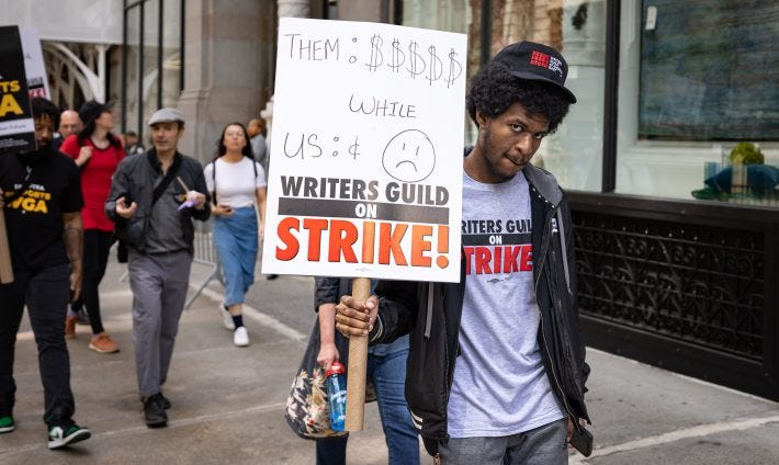 A member of Writers Guild of America participates in a march on a picket line in front of Netflix offices. After contract negotiations failed, thousands of unionized writers voted unanimously to strike, bringing television production to a halt, and initiating the first walkout in 15 years.