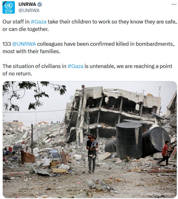 Screen capture of a UNRWA tweet @UNRWA. Tweet reads: "Our staff in #Gaza take their children to work so they know they are safe, or can die together. 133 @UNRWA colleagues have been confirmed killed in bombardments, most with their families. The situation of civilians in #Gaza is untenable, we are reaching a point of no return." The tweet includes a color photo of a man walking through the aftermath of an IOF attack in Gaza. The man is wearing a baseball cap, short sleeved shirt, and jeans. He is walking towards the camera, his head turned towards the right side of his body. In his arms, on the left side of his body is a young child. The child has short hair, and is wearing ajacket, pants, and white sneakers. Another child is in the photo on the right side of the picture in profile, and seems to be running. In the background is the wreckage of what used to be a town. There are piles of debris and rubble, and a building that is almost completely destroyed. 