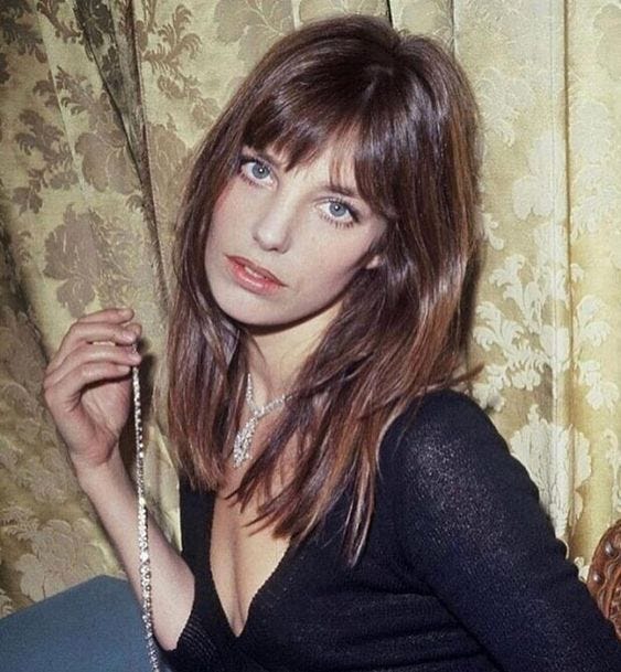 Jane Birken poses to the camera, showing bangs that touch her brows