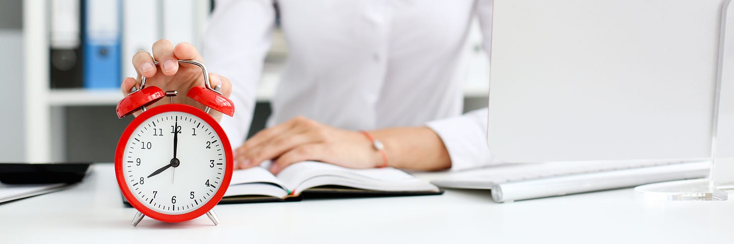 Picture of person with open book and hand on an analog clock