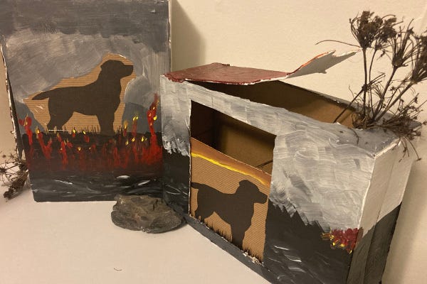Photograph of two painted cardboard boxes with images of dogs on them
